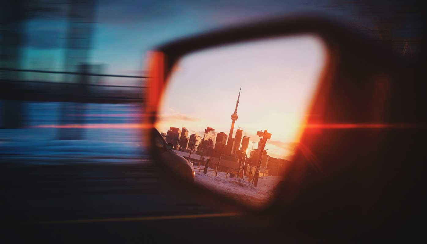 A sight of Toronto, Canada seen from a side mirror on a car.