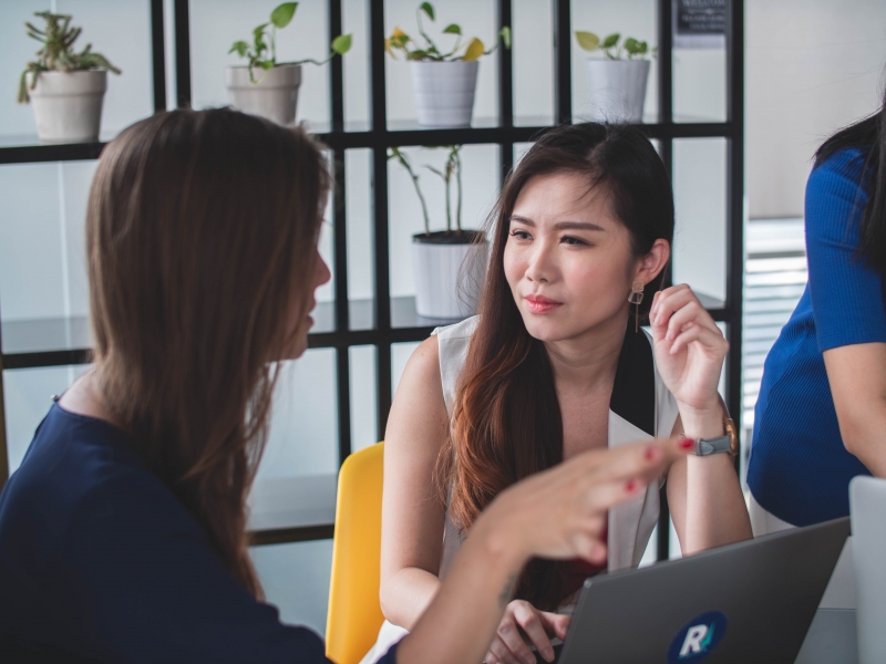 2 women having a conversation, one is Asian